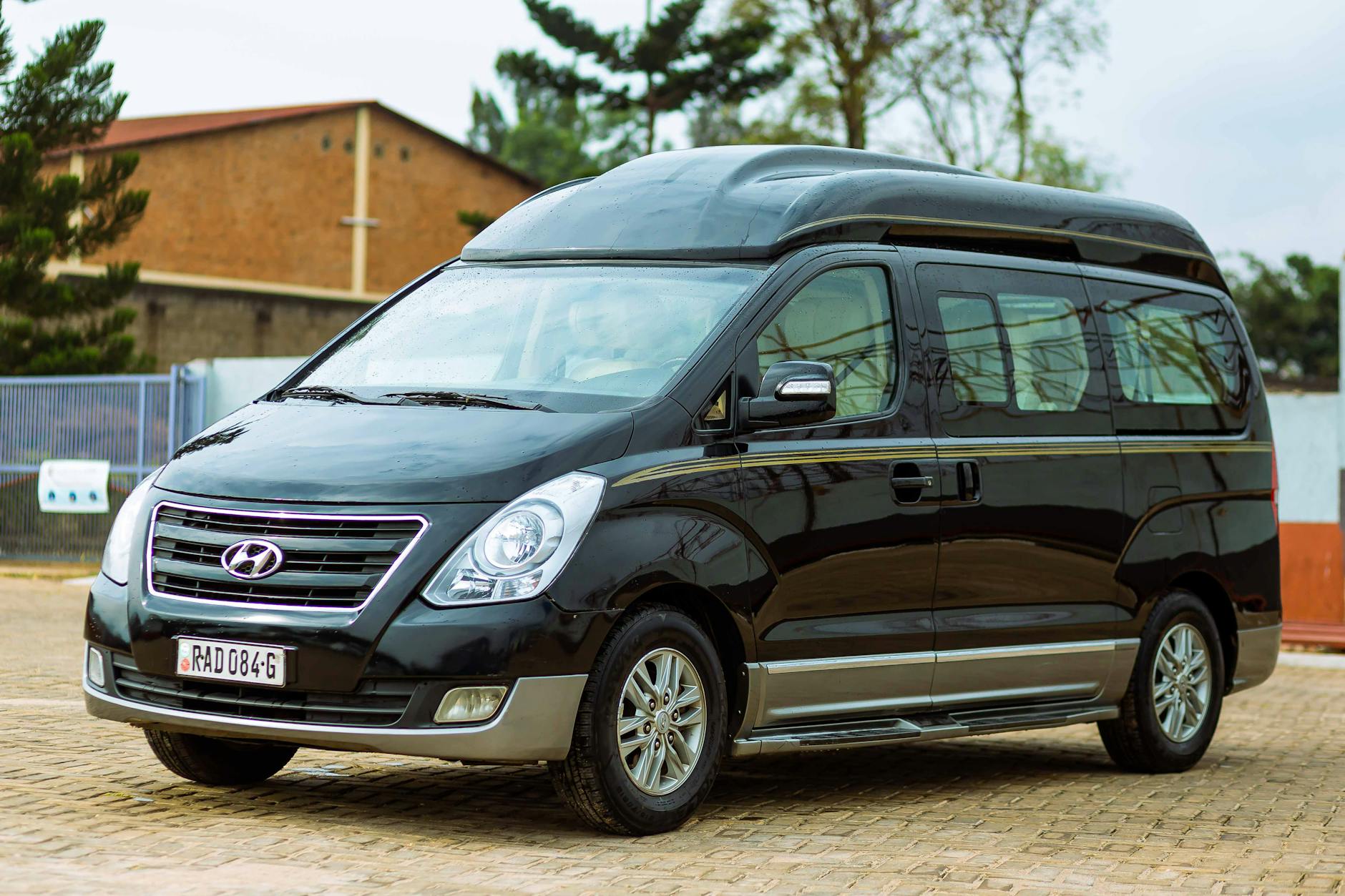 Czarny bus Hyundai zaparkowany na pustym parkingu za dnia