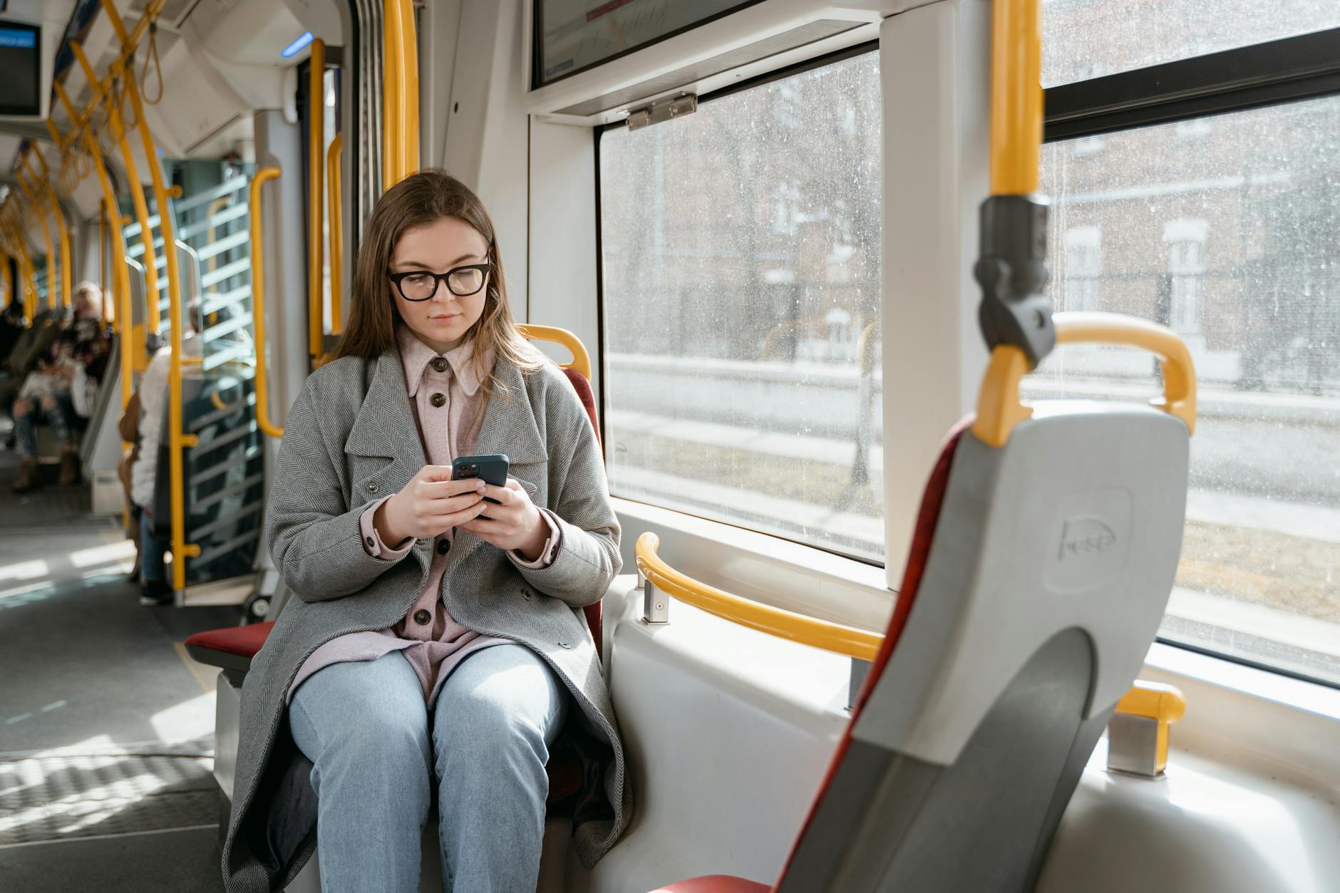Kobieta w tramwaju sprawdza w smartfonie informacje o bilecie