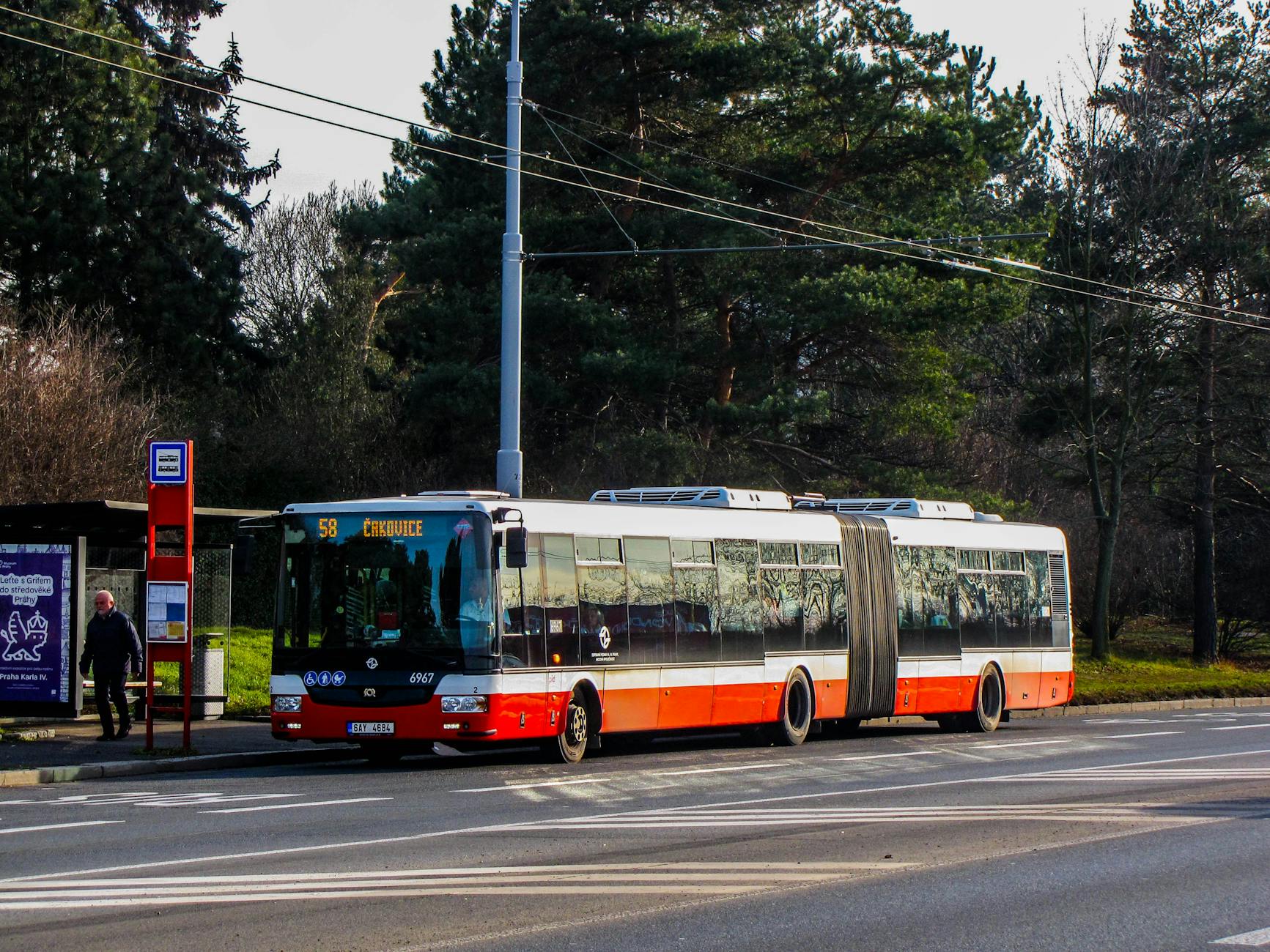 Przegubowy autobus na przystanku w Pradze w słoneczny dzień