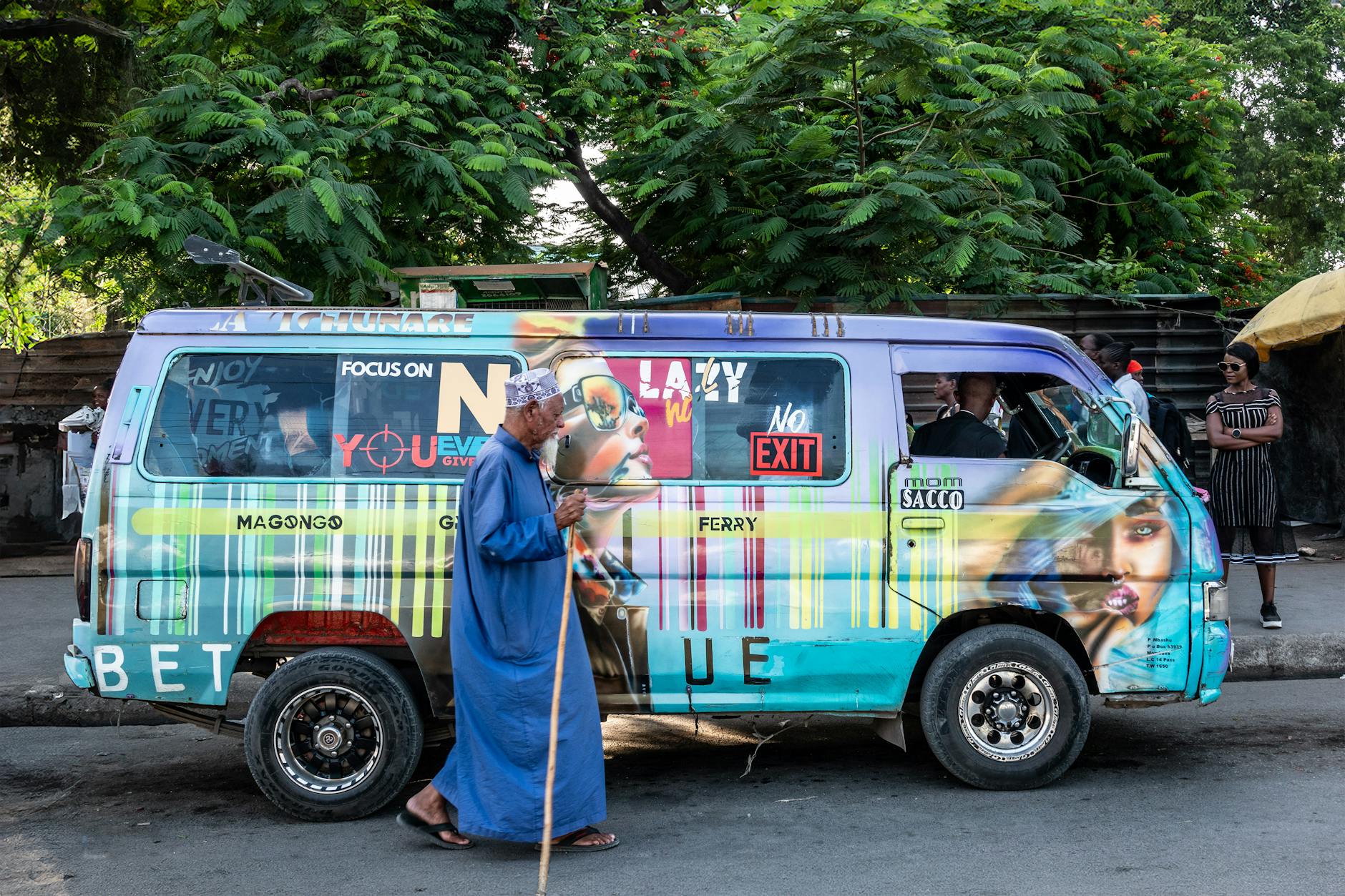 Kolorowy bus z graffiti na ulicy w Mombasie wśród przechodniów