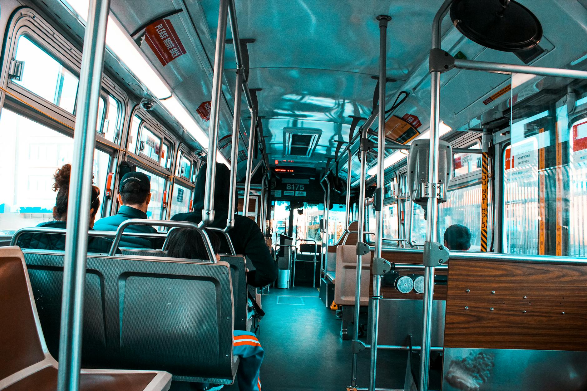 Pasażerowie różnych narodowości jadą miejskim autobusem do pracy