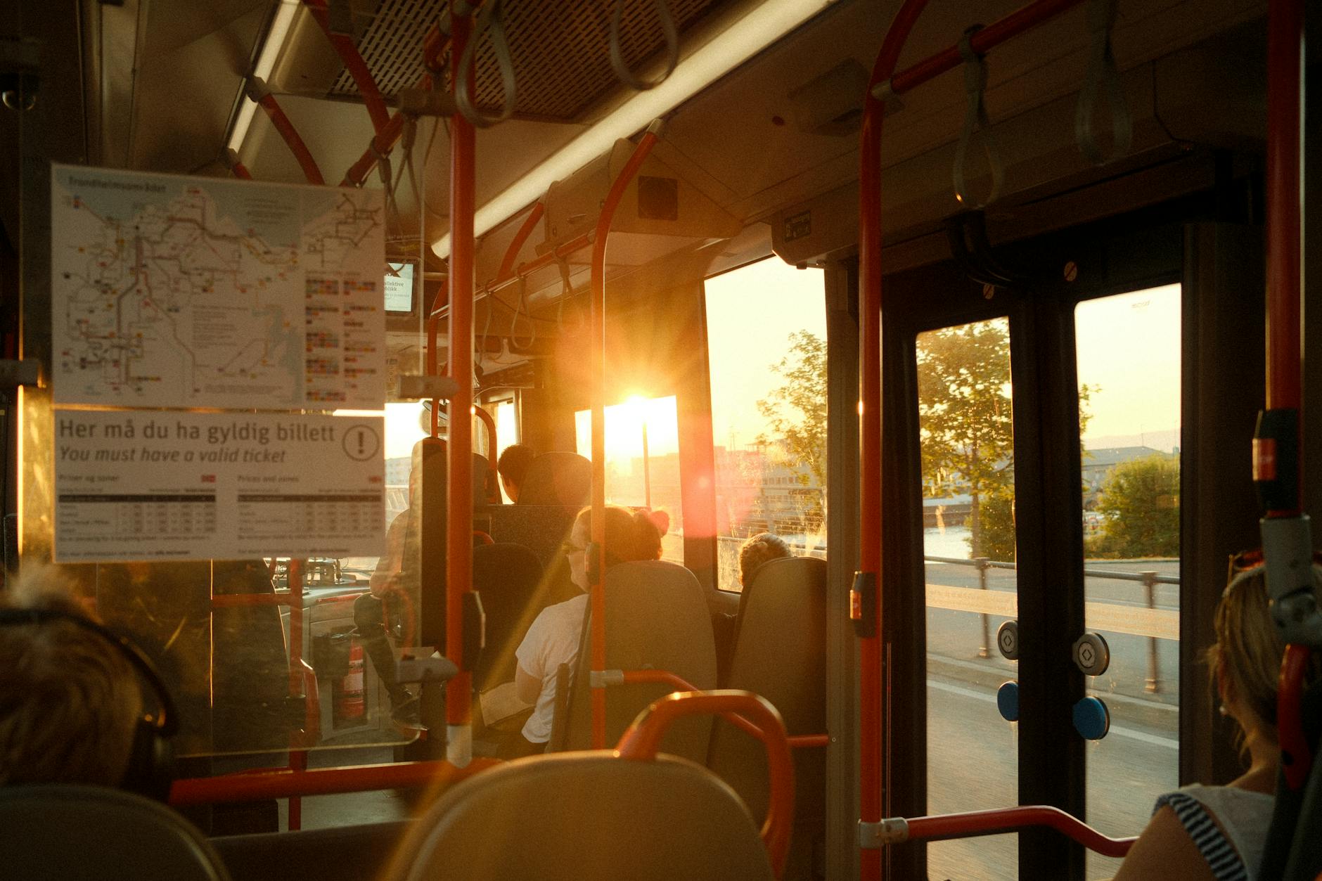 Pasażerowie w miejskim busie o zachodzie słońca