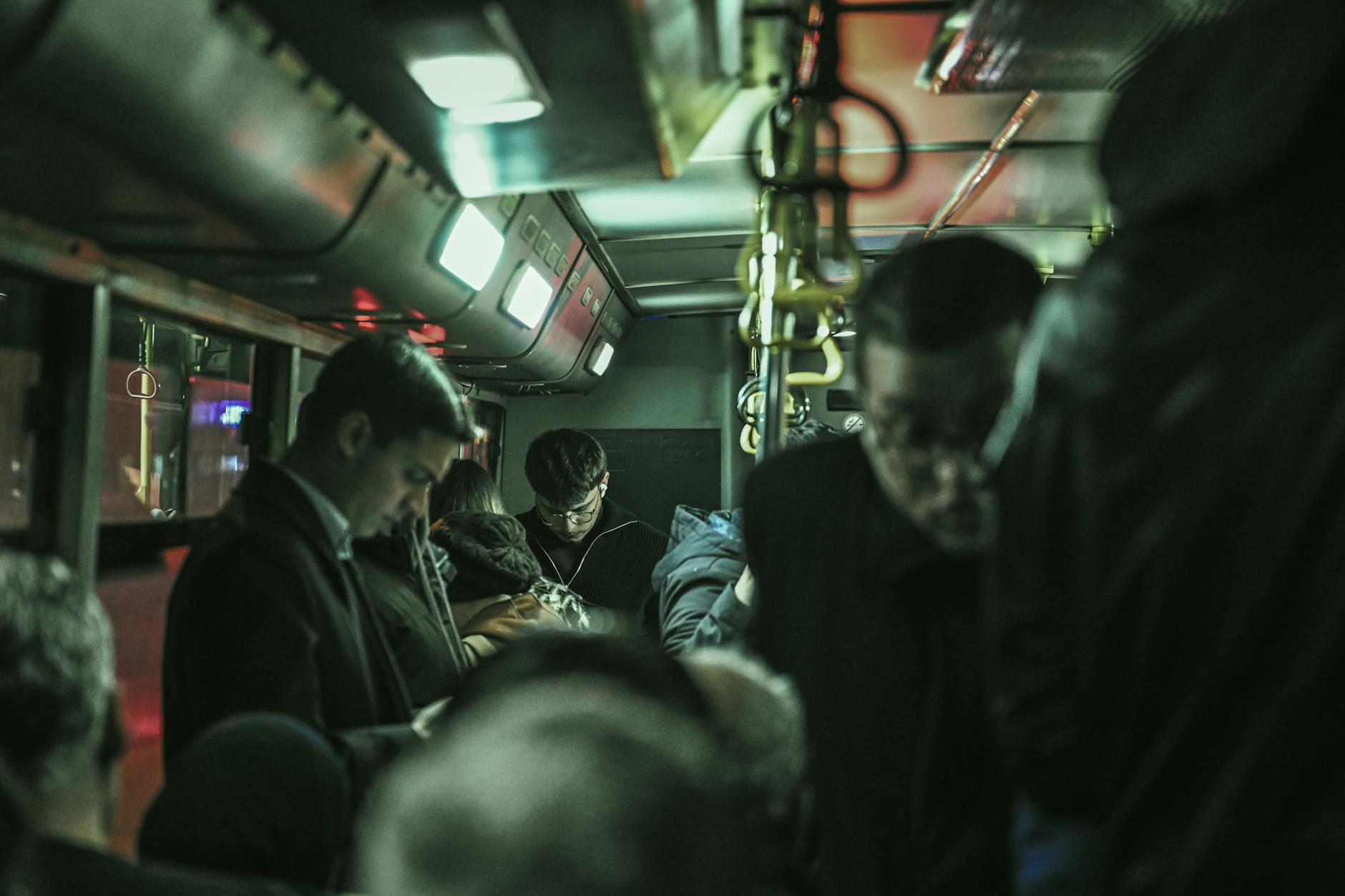 Pasażerowie w zatłoczonym nocnym autobusie miejskim