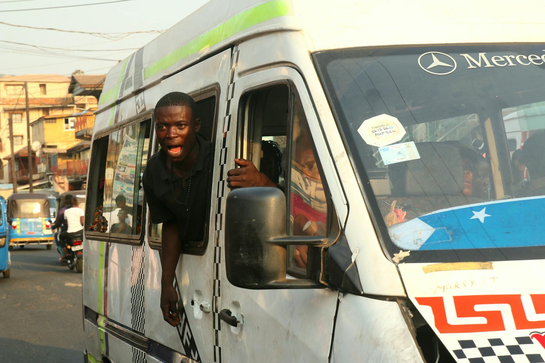 Rozmowni pasażerowie w zatłoczonym busie w Freetown