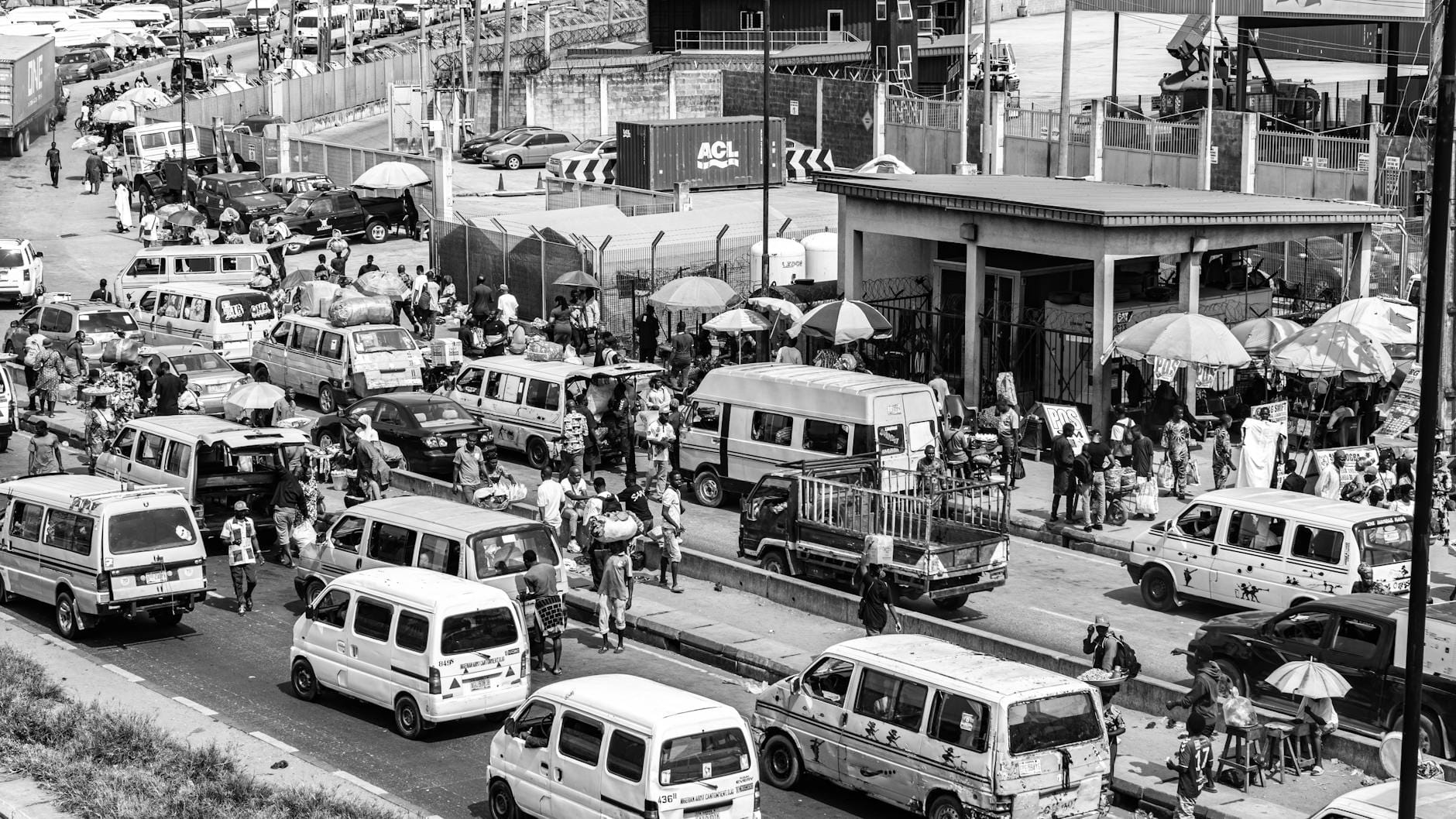 Zatłoczona ulica w mieście, samochody i piesi między straganami