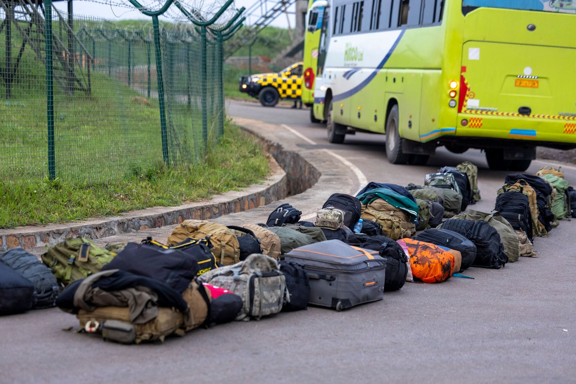 Torba sportowa czy walizka kabinowa: porównanie wygody w busie na długiej trasie Rząd plecaków i walizek ustawionych obok zielonego autobusu na parkingu
